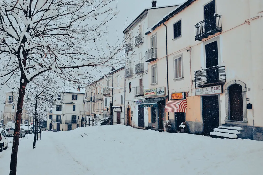 Zugeschneiter Gehweg und Straße vor dem Winterdienst